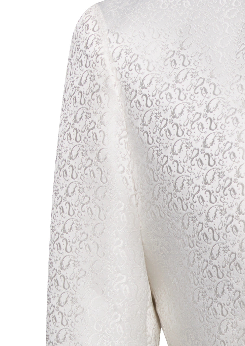 Detailed view of white paisley jacquard fabric and metallic crest buttons on tuxedo vest - Nevo Suits