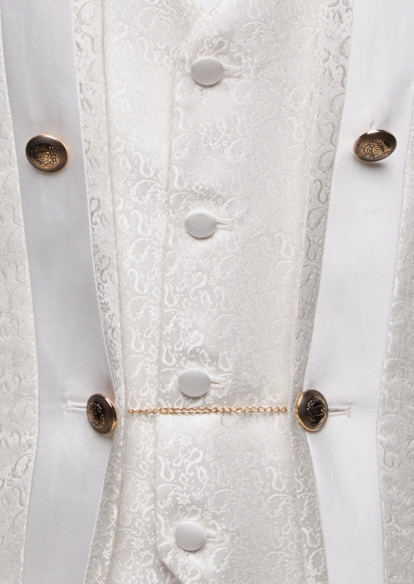 Detailed view of white paisley jacquard fabric and metallic crest buttons on tuxedo vest - Nevo Suits