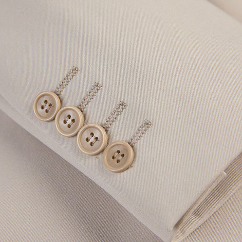 Detail view of tonal buttons on ivory beige suit sleeve