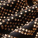 Macro view of amber-gold emerald-cut crystals on black obsidian fabric