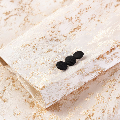 Close up of black covered buttons on gold jacquard jacket sleeve |
