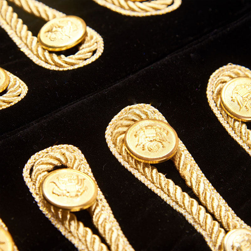 Detail of gold rope frogging and metal buttons on black velvet jacket - Nevo Suits