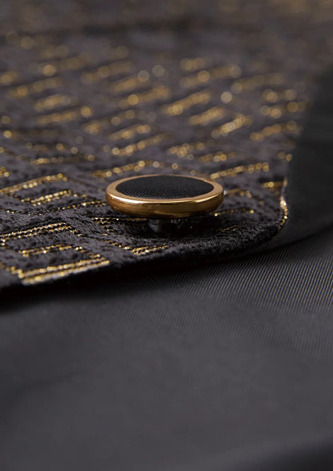 Model wearing Obsidian Eclipse black and gold greek-key jacquard tuxedo with satin peak lapels - Nevo Suits