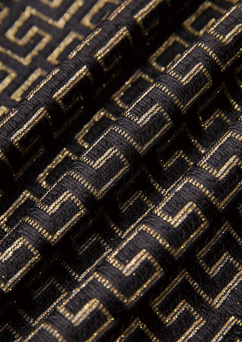 Model wearing Obsidian Eclipse black and gold greek-key jacquard tuxedo with satin peak lapels - Nevo Suits