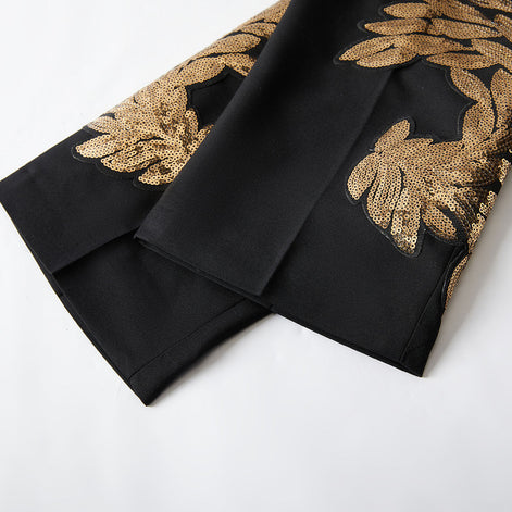Close up of matching gold sequin leaf embroidery at the hem of tuxedo pants