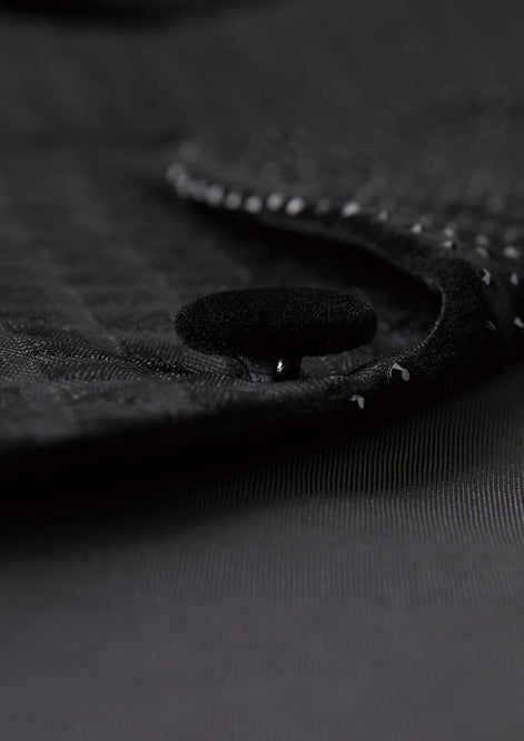 Close up of black velvet covered buttons on diamond jacquard sleeve