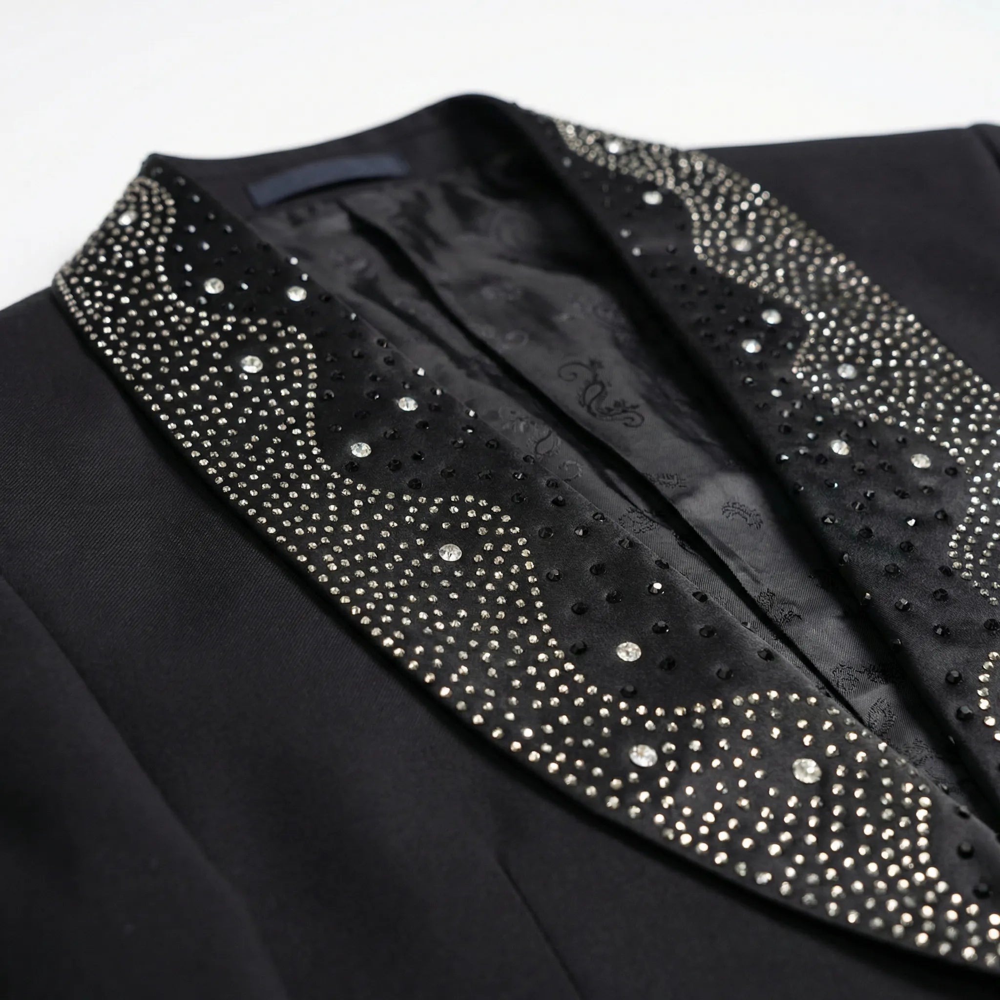 Detail view of wavy crystal pattern on black satin shawl lapel of Nevo tuxedo