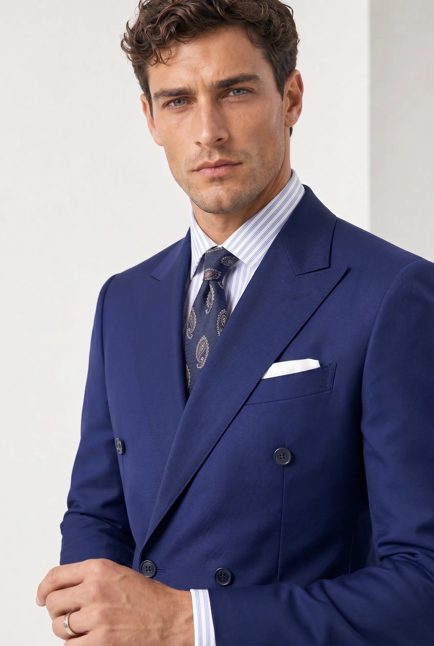 Ink Crownline royal blue peak lapel suit upper-body studio portrait
