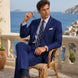 Ink Crownline royal blue 2-piece suit seated at a coastal terrace