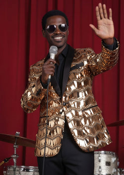 Man wearing The Phoenix Bronze metallic sequin tuxedo jacket performing on stage - Nevo Suits