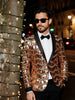 Man wearing a shiny gold jacket and black bow tie on a city street at night.
