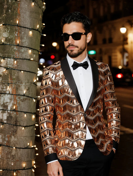 Man wearing a shiny gold jacket and black bow tie on a city street at night.