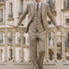 Man wearing The Saharan Pinstripe khaki herringbone suit in a luxury European setting - Nevo Suits