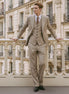 Man wearing The Saharan Pinstripe khaki herringbone suit in a luxury European setting - Nevo Suits