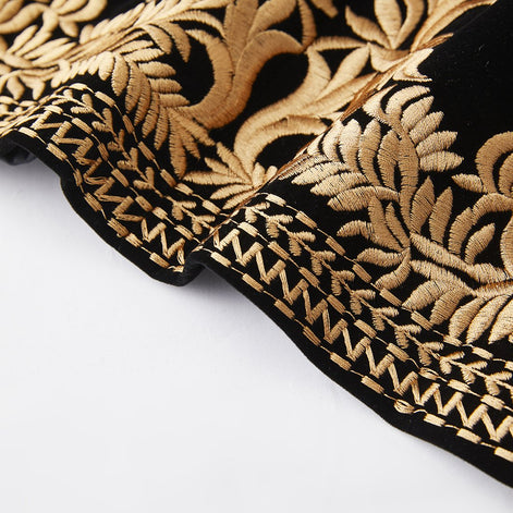 Gold embroidered hem detail on black velvet jacket
